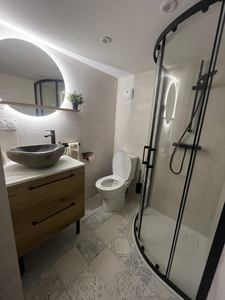 Bathroom with walk-in shower, stone basin and patterned tiles